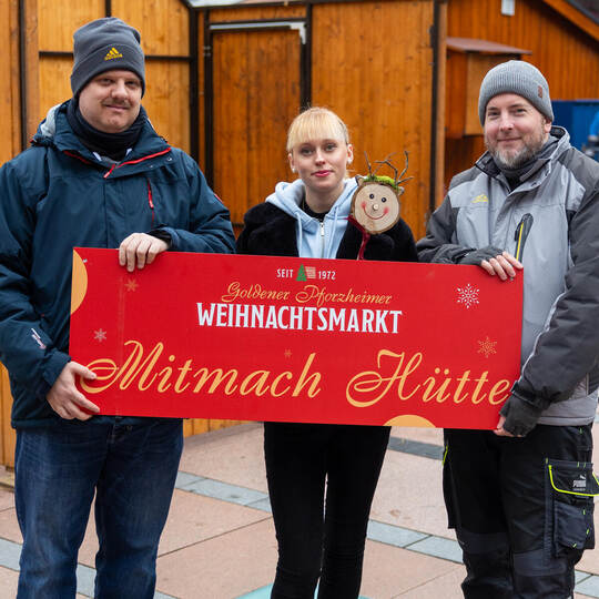 Jörg Folke (rechts) und Thilo Pross vom städtischen Marktamt sowie die PZ-Auszubildende Franziska Schübilla zeigen’s: Ganz beson Kunsthandwerk Hütten Weihnachtsmarkt Aufbau