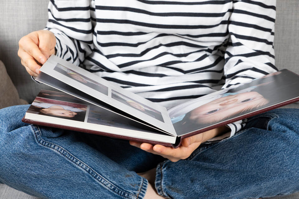 A woman looks at a photo book about her baby.