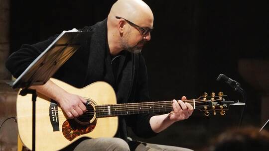 „Fools Garden“-Gitarrist Thorsten Kiefer balanciert sein Instrument locker auf dem Schenkel, während er ihm zart vor sich hin fl