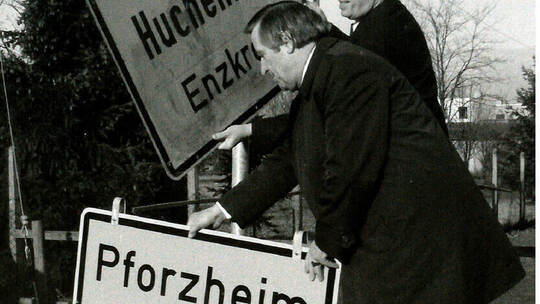 Symbolträchtiger Schilderwechsel: Huchenfelds Gemeinderat Hugo Sorg (links) und Pforzheims OB Dr. Willi Weigelt tauschen am 1. J