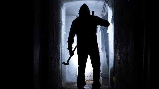 Ein Einbrecher in einem Keller