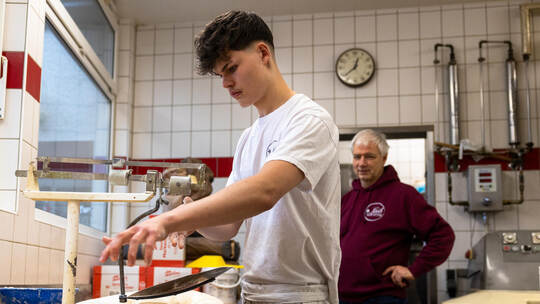 Azubi Tobias Bossok, wie er unter der Anleitung seines Chefs Martin Reinhardt den Teig für das Brot abwiegen. Bäcker Azubis Reinhardt Knittlingen