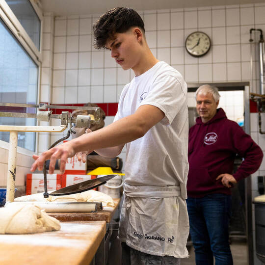 Azubi Tobias Bossok, wie er unter der Anleitung seines Chefs Martin Reinhardt den Teig für das Brot abwiegen. Bäcker Azubis Reinhardt Knittlingen