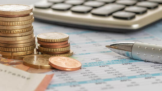 Geld mit Taschenrechner und Kugelschreiber