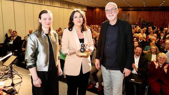 Organisator Gerhard Baral geleitete Tekkal zu ihrer Ehrung, der Preis wurde von der Pforzheimer Designerin Johanna Seibert (von