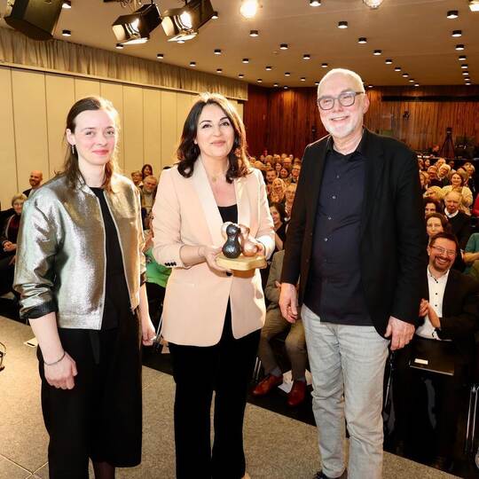 Organisator Gerhard Baral geleitete Tekkal zu ihrer Ehrung, der Preis wurde von der Pforzheimer Designerin Johanna Seibert (von