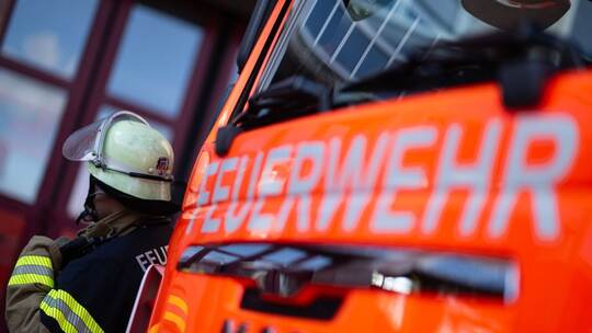 Feuerwehrmann neben Feuerwehrauto Feuerwehrmann neben Feuerwehrauto