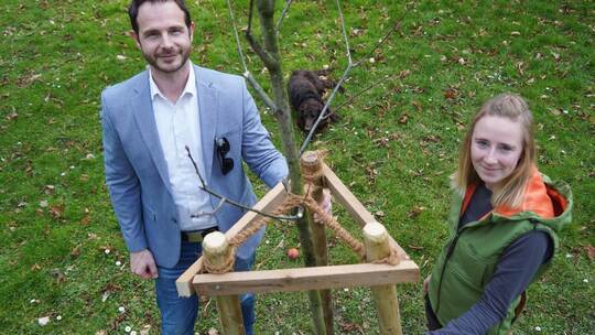 Bürgermeister Thomas Maag und SDW-Kreisgruppen-Geschäftsführerin Sarah Zwerenz stehen bei der neuen Roteiche, die in Bilfingen i