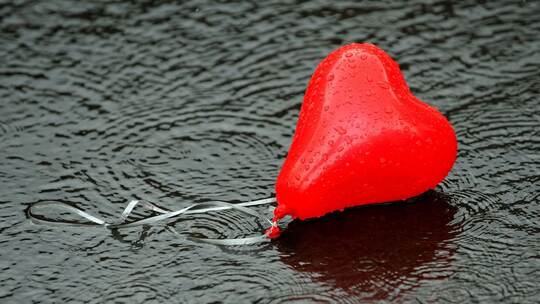 Herzluftballon liegt in einer Pfütze