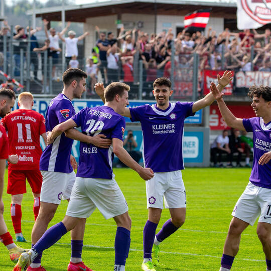 Die Nöttinger bejubeln das 1:0 von Benedikt Fassler. Im Hintergrund sieht es so aus, als würden die Reutlinger Fans mitfeiern.