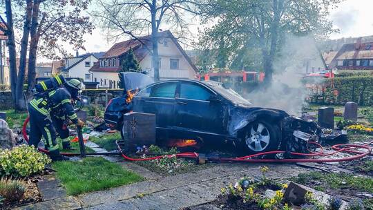 Auto fährt auf Friedhof und brennt auf Gräbern aus