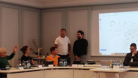 Klaus Weber (stehend von links, weißes T-Shirt) und Fabian Leeb stellen das Wohnprojekt für junge Senioren in der Sitzung des Ne