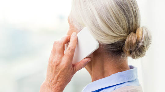 close up of senior woman calling on smartphone