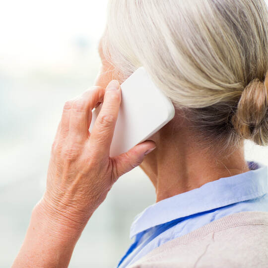 close up of senior woman calling on smartphone
