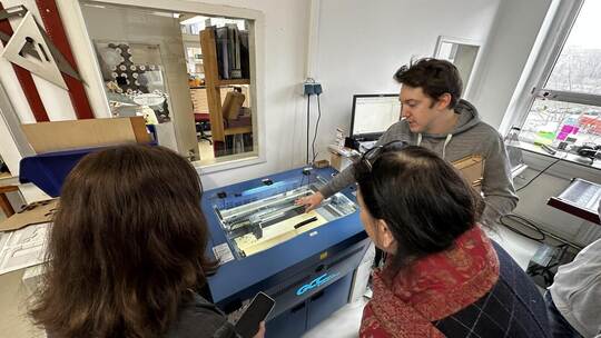 Mitarbeiter Barnabé Kaucic steht am Lasercutter in den Räumen von Q-Prints&Service als neuem digitalen Lernfeld des Projekts And