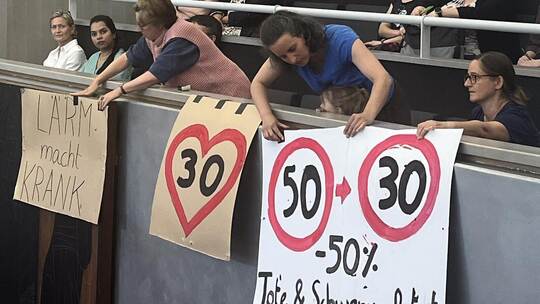 Stiller Protest: Mehrere Zuschauerinnen hissen in der Gemeinderatssitzung Plakate gegen die Tempo-50-Pläne des Gemeinderats. Kli