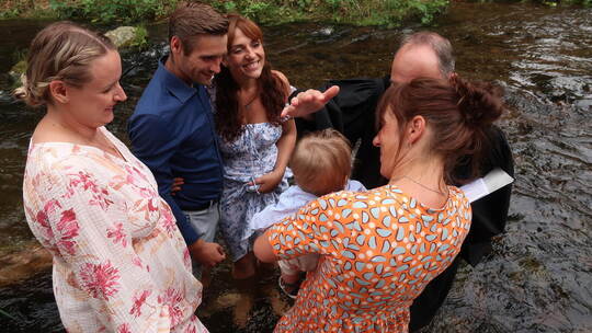 Pfarrer Mathias Kraft tauft mit frischem Enz-Wasser den kleinen Leon. Foto: Jennifer Warzecha