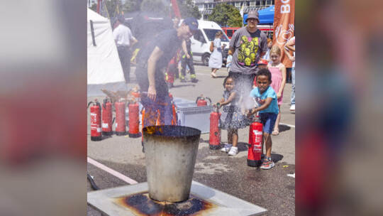 Lewi (sechs Jahre) und Bilisuma (drei Jahre) üben an dem Aktionstag mit den Feuerlöschern, wie man korrekt einen Brand bekämpfen Tag der Feuerwehr mit Leistungschau und Tag der offenen Tür in der Hauptfeuerwache.