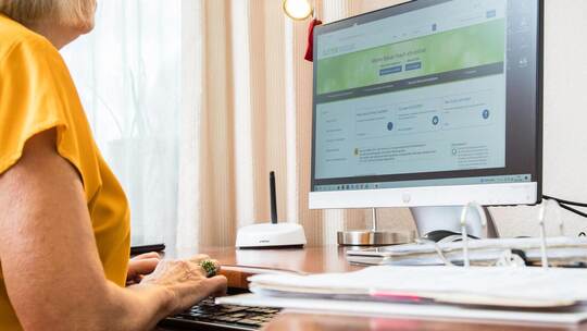 Seniorin macht eine Steuererklärung am PC