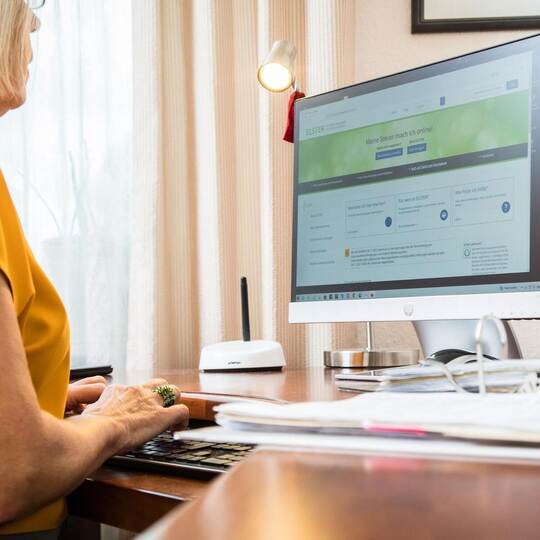 Seniorin macht eine Steuererklärung am PC
