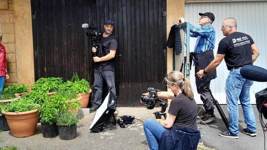 Ein komplettes Filmteam, Beleuchter (von rechts), Regisseur und zwei Kameraleute für die drei Protagonisten Renate und Roy Kiefe