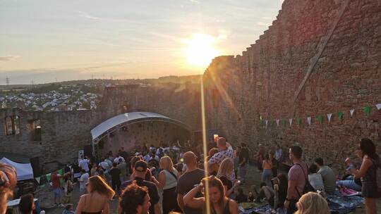 Das Publikum tanzt im Abendlicht zwischen den Burgmauern.