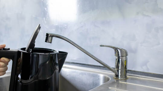 Electric kettle filling with tap water from kitchen sink, Daily water boiling preparation process