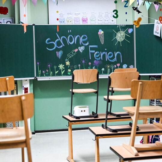 Hochgestellte Stühle und eine bemalte Tafel am letzten Schultag