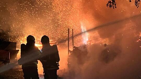 Fireman extinguish fire with the hose. Burning house fire drill