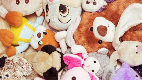 Many soft plush toys lie on floor in the children's room