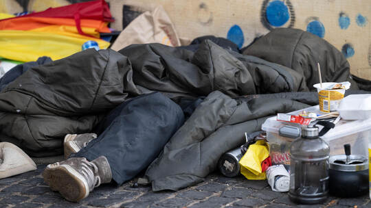 Nur ein Schlafsack bietet dem Wohnungslosen Schutz an einer Wand. Im Alter wird die Versorgung noch schwieriger, denn das Gesund Wohnungslosigkeit