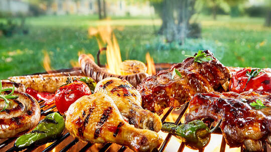Ist das lecker, wenn Grillgut auf heißer Glut brutzelt. Doch offenes Feuer ist in der Natur in trockenen Sommern ein Problem. Fo Assorted of mixed meats on a BBQ grill