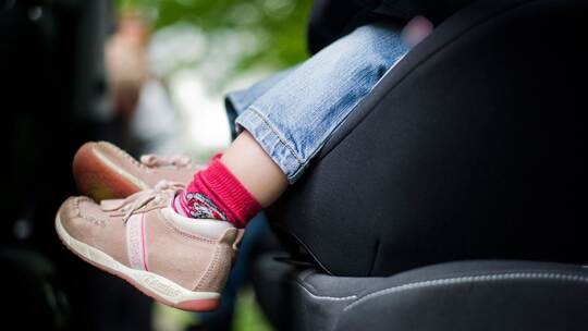 Mädchen sitzt in einem Kindersitz im Auto Mädchen sitzt in einem Kindersitz im Auto