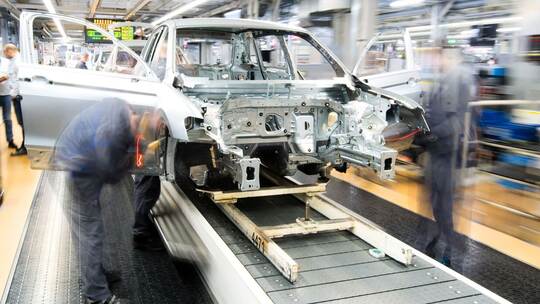 Mitarbeiter montieren Kotflügel an einem Auto Mitarbeiter montieren Kotflügel an einem Auto