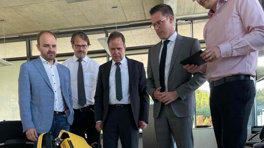 Der Roboterhund reckt und streckt sich, was fasziniert beobachtet wird von: CDU-Landtagskandidat Andreas Renner, Professor Raine