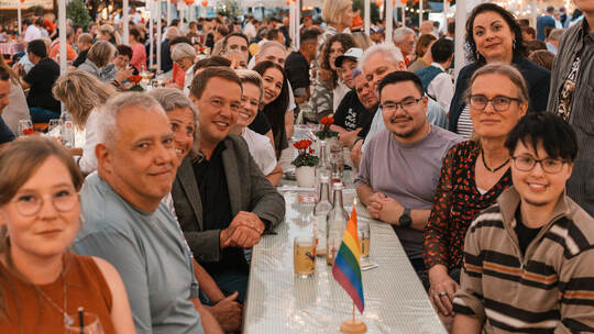 Die Besucherinnen und Besucher des Regenbogenstammtisches feiern ausgelassen, darunter Oliver Hildenbrand (Vierter von links) un
