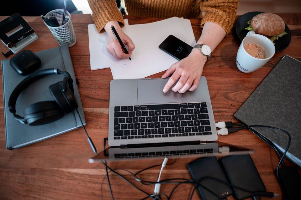 Frau arbeitet daheim an einem Laptop