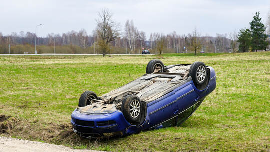 Car accident scene, a passenger car left the road and overturned upside, car rollover