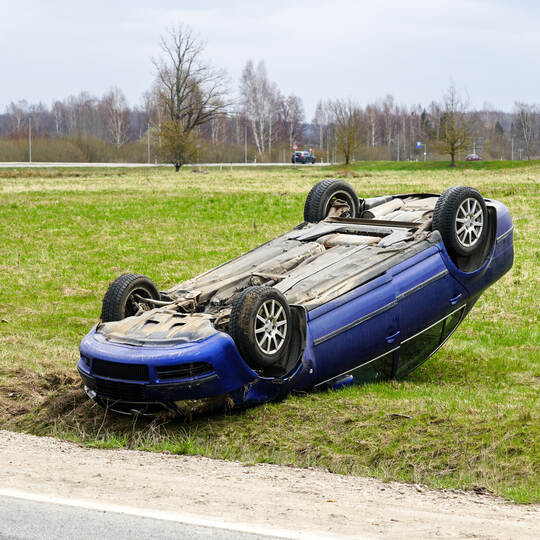 Car accident scene, a passenger car left the road and overturned upside, car rollover