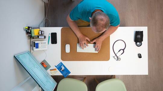 Ein Hausarzt sitzt in einem Sprechzimmer