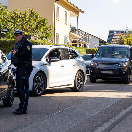 Polizeihauptkommissar Holger Kuhles kontrolliert eine Autofahrerin auf der Lindenstraße in Bauschlott. Die Autos stauen sich im Verkehrskontrolle Bauschlott Lindenstraße