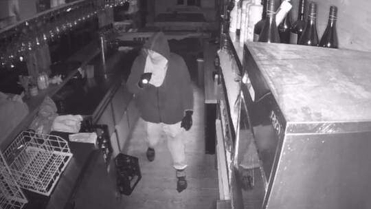 Aufnahme der Überwachungskamera aus der EventAlm: Einer der Einbrecher durchsucht die Bar des Gasthauses. Screenshot Instagram/m