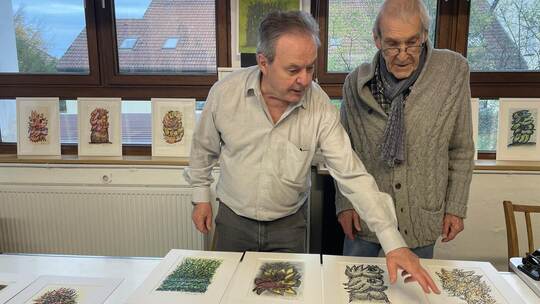 Gerhart Odenwald (links) stellt Axel Hertensteins noch nie öffentlich präsentierte Originale auf Papier in der Wagnerstraße 10 a