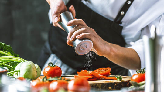 Chefkoch in der Küche mit Frischem Gemüse(Tomaten)