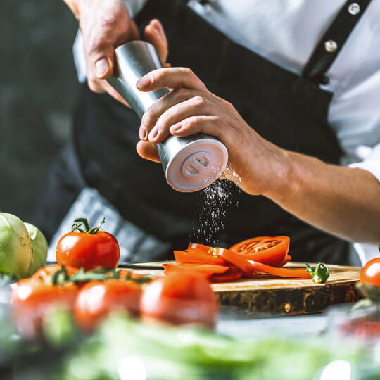 Chefkoch in der Küche mit Frischem Gemüse(Tomaten)