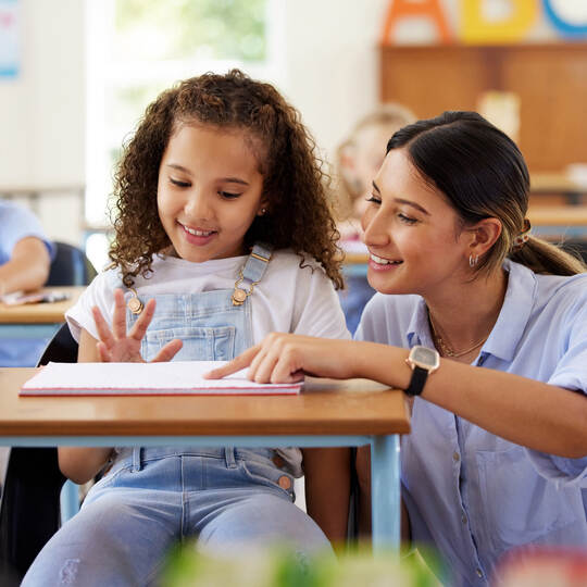 Learning to share is one of the skills we learn at preschool. Shot of a female teacher assisting a preschool learner in her clas