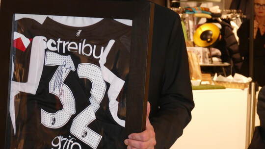 Karsten Jung präsentiert das von Vincenzo Grifo signierte SC-Trikot.