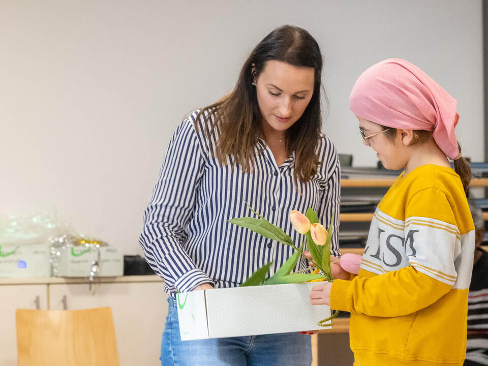 Nefise (rechts) hilft Stella Zeh beim Verteilen der Tulpen für die Mitmach-Aktion. MiN Weihnachten Walter-Geiger-Haus