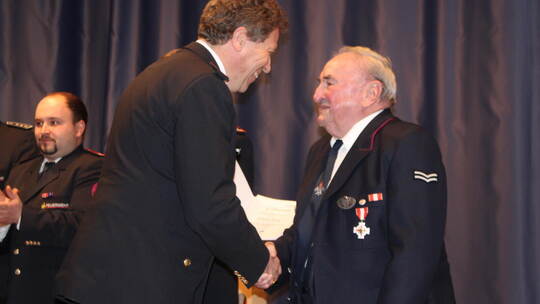 Wilhelm König wird von Markus Fritsch, dem Vorsitzenden des Kreisfeuerwehrverbandes Calw, mit dem Feuerwehrehrenzeichen in Gold