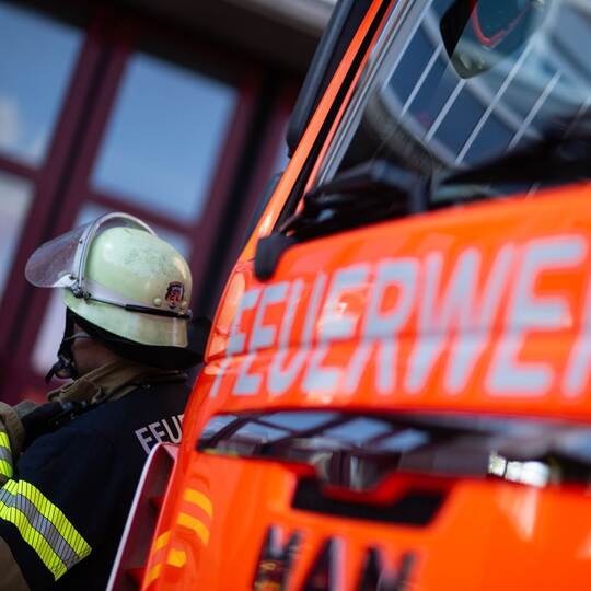 Feuerwehrmann steht neben einem Feuerwehrauto